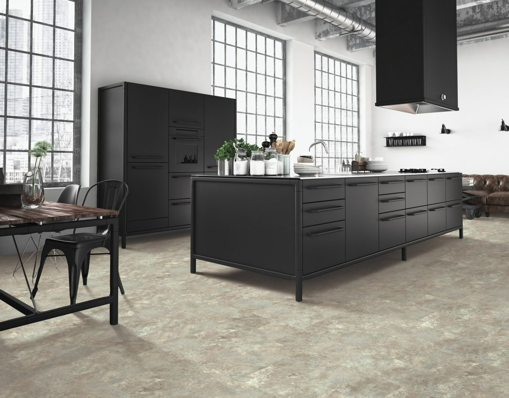 Grey stone lvt floors provide a chic backdrop for a sleek modern kitchen with black cabinetry and appliances.